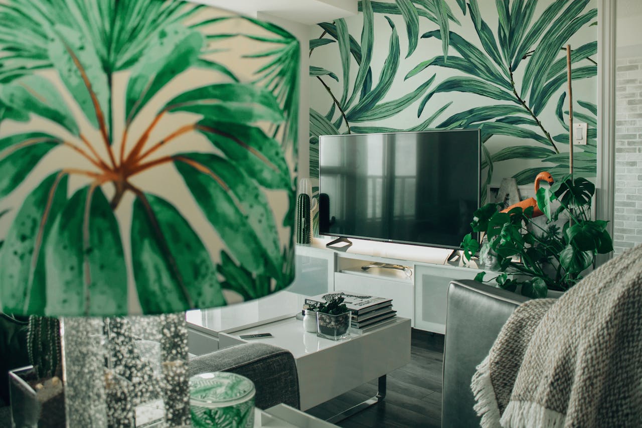 A cozy modern living room features tropical decor and indoor plants.