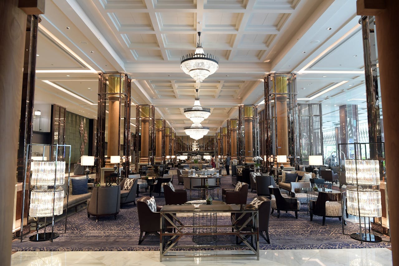 service-03 Spacious and elegant hotel lobby with luxurious seating and grand chandeliers, offering a sense of opulence and relaxation.